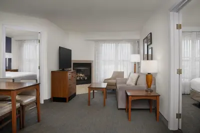 a hotel room with a couch and a bed and a living room at Residence Inn by Marriott San Bernardino in San Bernardino