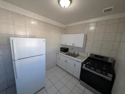 a kitchen with a white refrigerator and a sink at Seaside Inn Motel in Port Hueneme