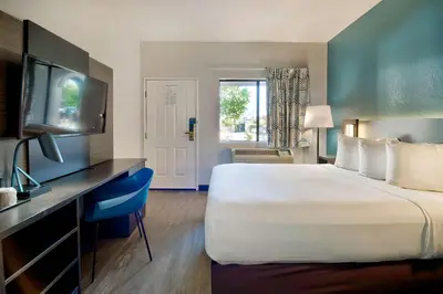 a hotel room with a large bed and a desk at Studio 6 Suites Lawndale, CA South Bay in Lawndale