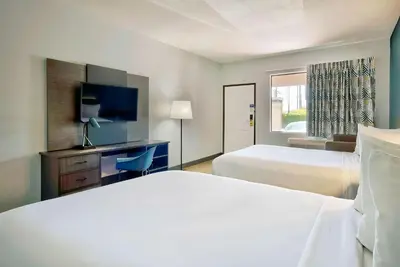 a hotel room with two beds and a flat screen tv at Studio 6 Suites Lawndale, CA South Bay in Lawndale