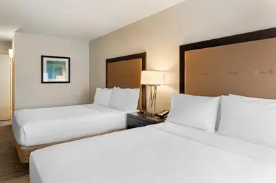 two beds in a hotel room with white sheets at Holiday Inn Express San Bernardino Colton by IHG in Colton