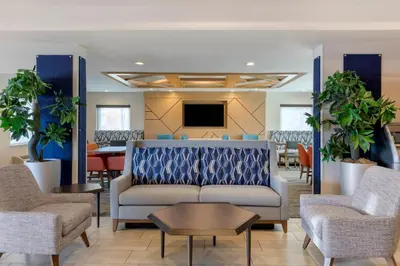 a lobby with a couch and chairs and a tv at Holiday Inn Express San Bernardino Colton by IHG in Colton