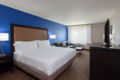 a hotel room with a large bed and a blue wall at Holiday Inn Express San Bernardino Colton by IHG in Colton