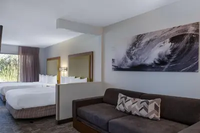 a hotel room with two beds and a couch at SpringHill Suites Pasadena Arcadia in Arcadia