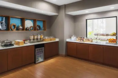 a restaurant with a counter with food on display at SpringHill Suites Pasadena Arcadia in Arcadia