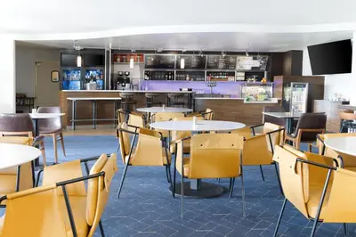 a restaurant with tables and chairs and a bar at Courtyard by Marriott Ontario Rancho Cucamonga in Rancho Cucamonga