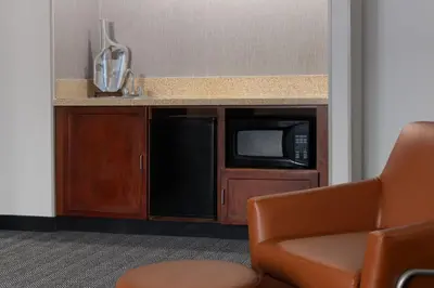 a kitchen with a microwave and a chair in a room at Courtyard by Marriott Ontario Rancho Cucamonga in Rancho Cucamonga