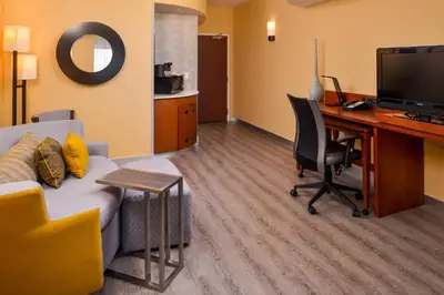 a living room with a couch and a desk with a computer at Courtyard by Marriott Victorville Hesperia in Hesperia