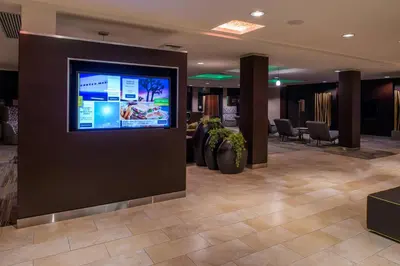 a lobby with a flat screen tv on a wall at Courtyard by Marriott Victorville Hesperia in Hesperia