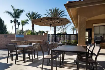 a patio with tables and chairs and an umbrella at Residence Inn by Marriott Camarillo in Camarillo