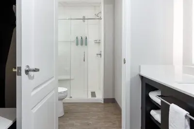 a white bathroom with a shower and a toilet at Residence Inn by Marriott Corona Riverside in Corona