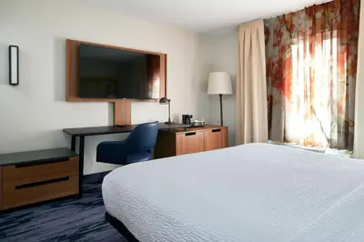 a hotel room with a bed and a desk and a television at Fairfield Inn and Suites San Bernardino in San Bernardino