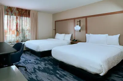 a hotel room with two beds and a desk at Fairfield Inn and Suites San Bernardino in San Bernardino