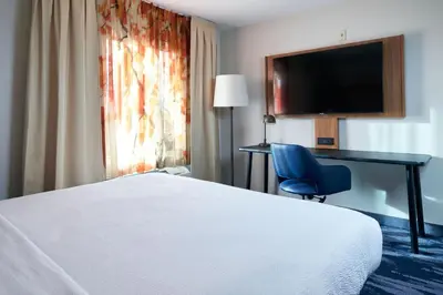 a hotel room with a bed and a desk and a chair at Fairfield Inn and Suites San Bernardino in San Bernardino