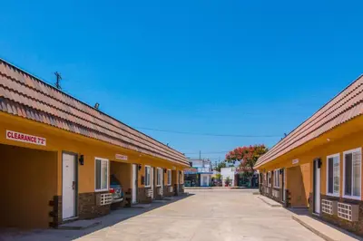 an empty street in a town with yellow buildings at El Dorado Inn in Lynwood