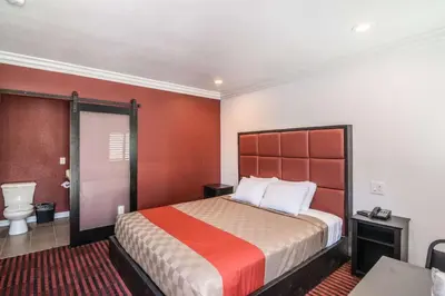 a hotel room with a bed and a toilet at El Dorado Inn in Lynwood