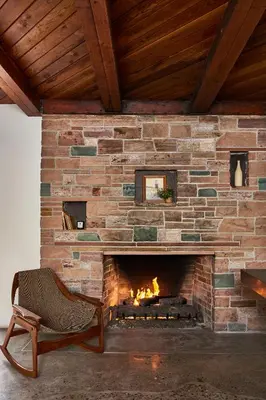 a brick fireplace with a chair in front of it at Hotel June Malibu in Malibu