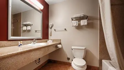 a bathroom with a toilet and a sink and a mirror at Best Western Burbank Airport Inn in Los Angeles