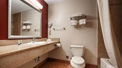 a bathroom with a toilet and a sink and a mirror at Best Western Burbank Airport Inn in Los Angeles