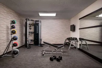 a room with a gym with a bench and weights at Sonesta Select Camarillo in Camarillo