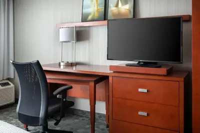 a desk with a television and a chair in a hotel room at Sonesta Select Camarillo in Camarillo