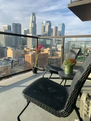 a balcony with two chairs and a table with flowers on it at Top Floor 3 Bed 3 Bath Penthouse Living In Luxury in Los Angeles