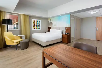 a hotel room with a bed and a table and chairs at Courtyard by Marriott Santa Monica in Los Angeles