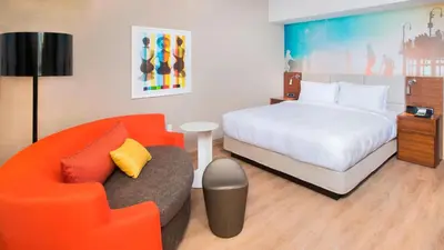 a bedroom with a bed and a couch and a chair at Courtyard by Marriott Santa Monica in Los Angeles