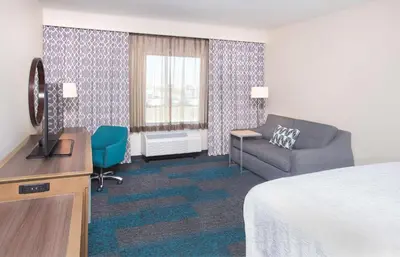 a hotel room with a bed and a tv and a couch at Hampton Inn & Suites LAX El Segundo in El Segundo