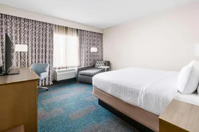 a hotel room with a bed and a desk and chair at Hampton Inn & Suites LAX El Segundo in El Segundo