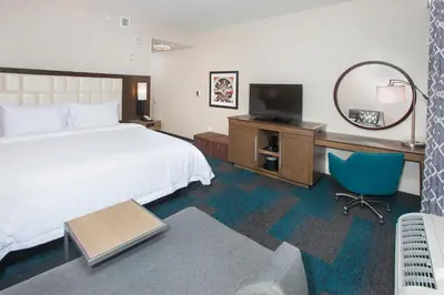 a hotel room with a bed and a desk with a television at Hampton Inn & Suites LAX El Segundo in El Segundo