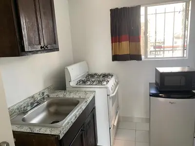 a kitchen with a sink and a stove and a microwave at Encore Inn Inglewood in Inglewood