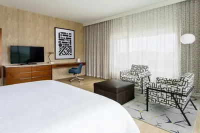 a hotel room with a bed and a desk and chairs at Hampton Inn & Suites Santa Monica in Los Angeles