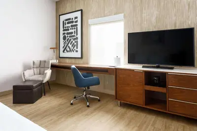 a room with a desk with a television and a chair at Hampton Inn & Suites Santa Monica in Los Angeles