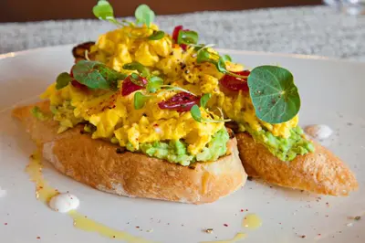 two pieces of bread with scrambled eggs on a plate at Hotel Indigo Los Angeles Downtown by IHG in Los Angeles