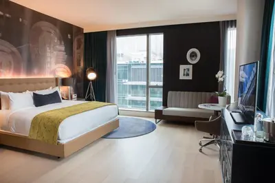 a bedroom with a bed and a couch and a television at Hotel Indigo Los Angeles Downtown by IHG in Los Angeles
