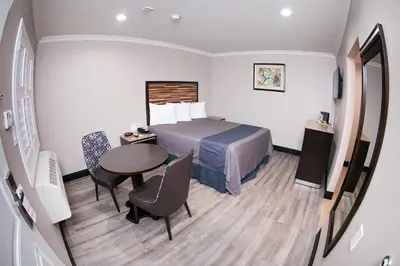 a hotel room with a bed and a table and chairs at Diamond Bell Inn & Suites in Bell
