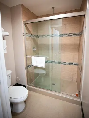 a bathroom with a glass shower with a toilet at Diamond Bell Inn & Suites in Bell