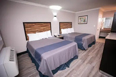 a hotel room with two beds and a television at Diamond Bell Inn & Suites in Bell