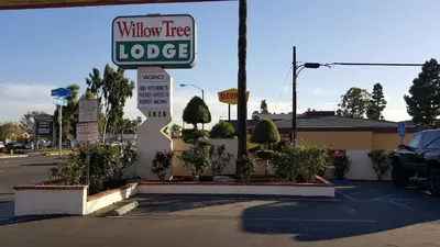 a sign for a wholin here lodge on a street at Willow Tree Lodge in Fullerton