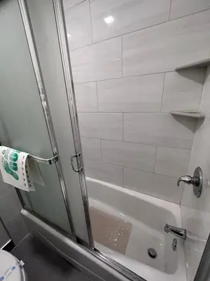 a shower with a glass door in a bathroom at Willow Tree Lodge in Fullerton