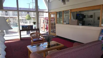 a lobby with a waiting area with chairs and a table at Willow Tree Lodge in Fullerton