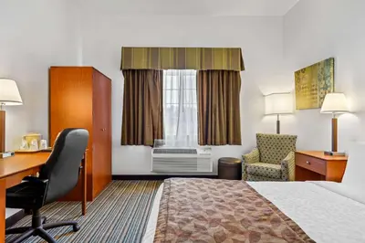 a hotel room with a bed and a desk and a chair at Best Western Liberty Inn in Delano