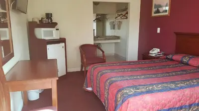 a hotel room with a bed and a desk at Victory Motel Inn near Universal & Hollywood in Glendale