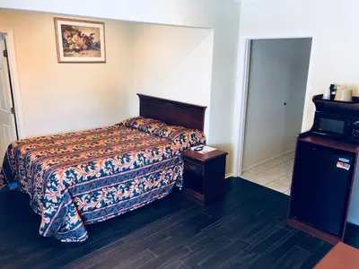 a hotel room with a bed and a table at Victory Motel Inn near Universal & Hollywood in Glendale