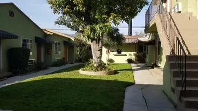a tree in a yard next to a building at Victory Motel Inn near Universal & Hollywood in Glendale