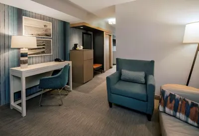 a hotel room with a desk and a chair and a table at SunCoast Hotel Anaheim, Tapestry Collection by Hilton in Anaheim