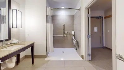 a bathroom with a shower and a sink at SunCoast Hotel Anaheim, Tapestry Collection by Hilton in Anaheim