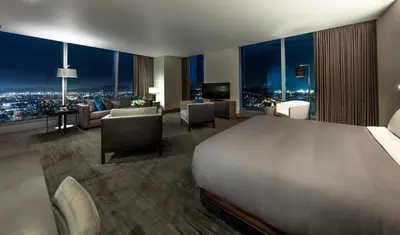 a bedroom with a large bed and a living room at InterContinental - Los Angeles Downtown by IHG in Los Angeles