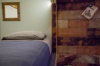 a bedroom with a bed and a wooden wall at PodShare East Hollywood in Los Angeles